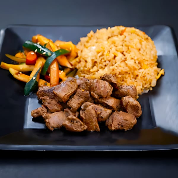 Hibachi Bus Stop's hibachi steak with fried rice and mixed vegetables on a black plate.