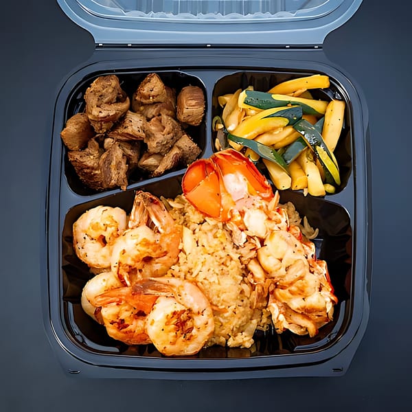 Hibachi Bus Stop's hibachi meal with steak, shrimp, lobster, fried rice, and zucchini in a to-go container.