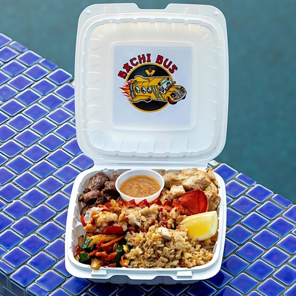 Hibachi Bus Stop hibachi meal in a white takeout container with steak, chicken, lobster, rice, and vegetables.