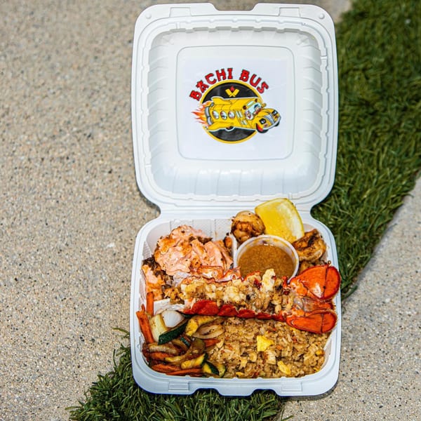 Hibachi Bus Stop takeout container with lobster, salmon, shrimp, fried rice, and vegetables.